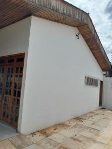 a large white building with a wooden door at Ampla Casa Duplex com 4 suítes in Teresina