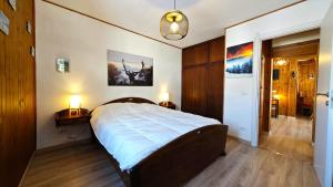 a bedroom with a large bed and two lamps on tables at Hostdomus - Seguret in Cesana Torinese