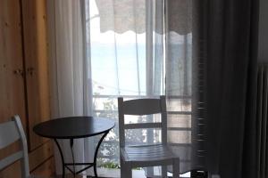 a table and a chair and a table and a window at Papas Studios On the Seafront in Oreoí