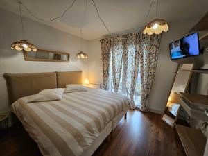 1 dormitorio con 1 cama, TV y ventana en le loft bleu (12 couchages), en Sablons