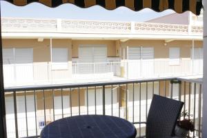 un balcone con sedia blu e un edificio di El Descans Solo Familias Serviplaya a Casas Las Basas