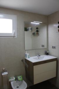bagno con lavandino e specchio di El Descans Solo Familias Serviplaya a Casas Las Basas