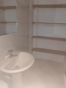 een witte badkamer met een wastafel en planken bij Cabaña mi negra linda in San Antero