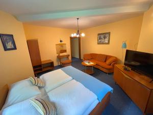 Habitación de hotel con cama y sofá en Motel na vrchu Baba s.r.o. en Pezinok