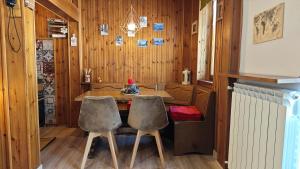 a dining room with a table and two chairs at Hostdomus - Seguret in Cesana Torinese +21 photos
