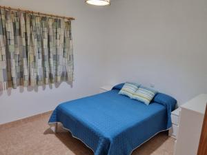 コティージョにあるCasa cotilloのベッドルーム(青いベッド1台、窓付)