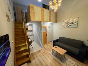 a small living room with a couch and a staircase at City Center Apartman in Satu Mare