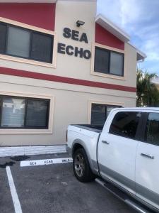 a white truck parked in front of a store at SEA ECHO APPARTMENT MOTEL in Fort Lauderdale