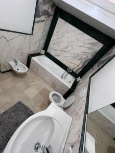 La salle de bains est pourvue de toilettes blanches et d'un lavabo. dans l'établissement Villa 3alame, à Temara