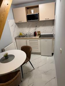 a small kitchen with a table and a microwave at City Center Apartman in Satu Mare