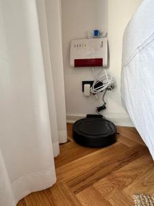a black vacuum sitting on a wooden floor next to a bed at Exklusive Ferienwohnung im Stadtzentrum - 24h Check-in in Kiel