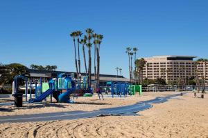 a playground on a beach with palm trees and a building at Exclusive property in the heart of marina del rey in Los Angeles