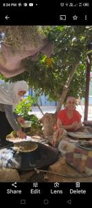 una mujer está haciendo una pizza en una mesa en Family House en Al Azraq ash Shamālī