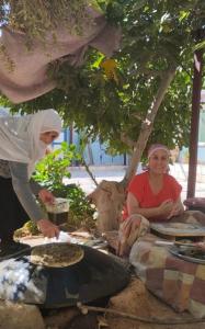 Eine Frau, die Essen auf dem Grill kocht in der Unterkunft Family House in Al Azraq ash Shamālī