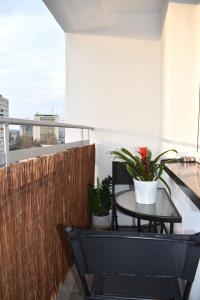 a balcony with a table and two potted plants at Apartament MCK 100m, Spodek 150m, NOSPR in Katowice