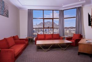 a living room with red couches and a large window at فندق روزن المسك مكة توصيل للحرم in Al ‘Azīzīyah