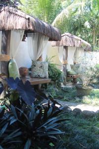 um jardim com uma mesa de madeira e uma cabana de palha em Pousada D'Pillel em Abraão