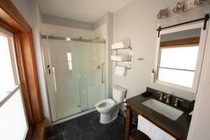 a bathroom with a shower and a toilet and a sink at The Y On Broadway in Jim Thorpe