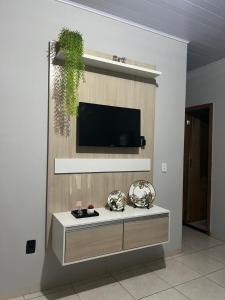 uma sala de estar com uma televisão na parede em Loft 05 Excelente Localização em Cuiabá