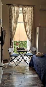 een slaapkamer met een tafel en stoelen en een raam bij B&B Bella 'Mbriana Simona in Napels