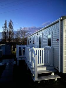 ein blaues Mobilheim mit einer Veranda und einer Treppe in der Unterkunft Laguna- Rockley Park Poole in Poole