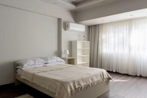 - une chambre blanche avec un lit et une fenêtre dans l'établissement Ultra-modern 4BR in Maadi Degla, au Caire