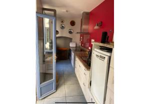 a kitchen with red walls and a white refrigerator at Maison de l horloge in Avallon +4 photos