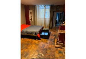 a bedroom with a bed and a room with a window at Maison de l horloge in Avallon