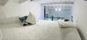 Una cama blanca con dos almohadas encima. en Apartment with loft in Altos del Maria en Sorá