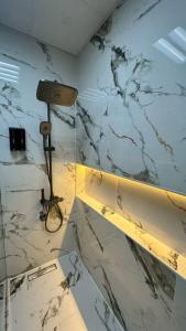 a bathroom with a marble wall with a lamp at TOP VIEW Luxury 1-bedroom amazing view in Ajman  +11 photos