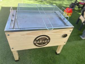 een houten tafel met een vogelkooi op het gras bij Mi casita de madera in Segovia