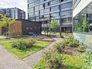 a garden in front of a large building at Studio next to train station, 7 mins by train to airport in Vantaa