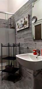 y baño con lavabo blanco y espejo. en B&B Bella 'Mbriana Simona, en Nápoles