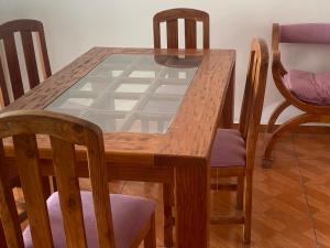 uma mesa de madeira e cadeiras com uma mesa de vidro em Baquedano em Antofagasta