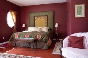 a bedroom with a bed and a couch at Rumi Guest House on the Cabot Trail in Indian Brook
