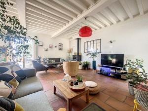 a living room with a couch and a tv at Jolie maison au pied du Luberon in Cucuron