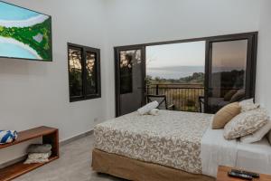 a bedroom with a bed and a balcony at Vida Palace in Jacó