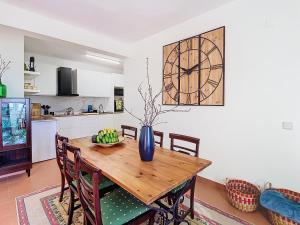 a dining room with a wooden table and a clock on the wall at Alojamento Funchal - Silvestre House in Funchal +19 photos