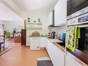 a kitchen with white cabinets and a counter top at Alojamento Funchal - Silvestre House in Funchal
