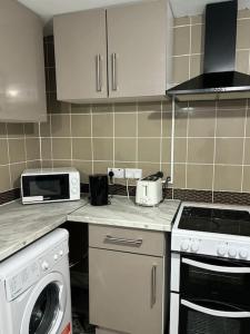 een keuken met een kookplaat, een oven en een magnetron bij Stunning 2 bed rear flat Manchester in Manchester
