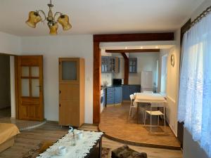 ein Wohnzimmer mit einem Tisch und einer Küche in der Unterkunft APARTAMENT NAD JEZIORKIEM KĘTRZYŃSKIM in Kętrzyn
