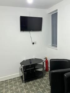 een woonkamer met een flatscreen-tv en 2 stoelen bij Stunning 2 bed rear flat Manchester in Manchester