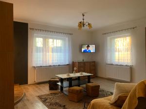 ein Wohnzimmer mit einem Tisch und einem TV in der Unterkunft APARTAMENT NAD JEZIORKIEM KĘTRZYŃSKIM in Kętrzyn