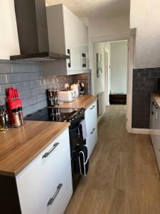 a kitchen with white appliances and a wooden counter top at King bed gym, fast Wi-Fi PS5, parking two spaces in Hereford