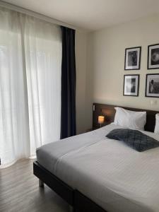 a bedroom with a large bed with white sheets at Hotel Locanda dei Mulini in Novazzano