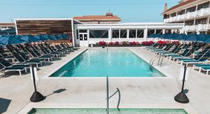 a swimming pool with chairs and a building at ICONA Avalon in Avalon