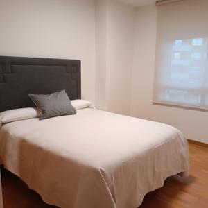 a white bed with a pillow on top of it at Apartamentos GO Covaresa -Parking Gratuito in Valladolid