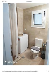 a bathroom with a white toilet and a mirror at D&K Studio - Nafplio in Nafplio