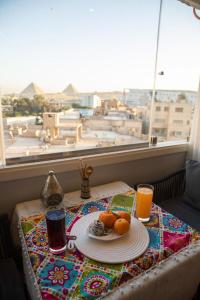 een tafel met een bord eten en twee glazen sinaasappelsap bij TOUT KING PYRIMDS VIEW in Caïro
