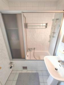 y baño con ducha, lavabo y bañera. en Romantic apartment with big terrace and garden view, en Viena